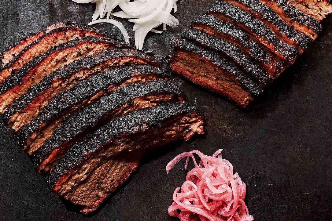 Sliced wood-smoked brisket with white onions and pickled red onions — The Asado.